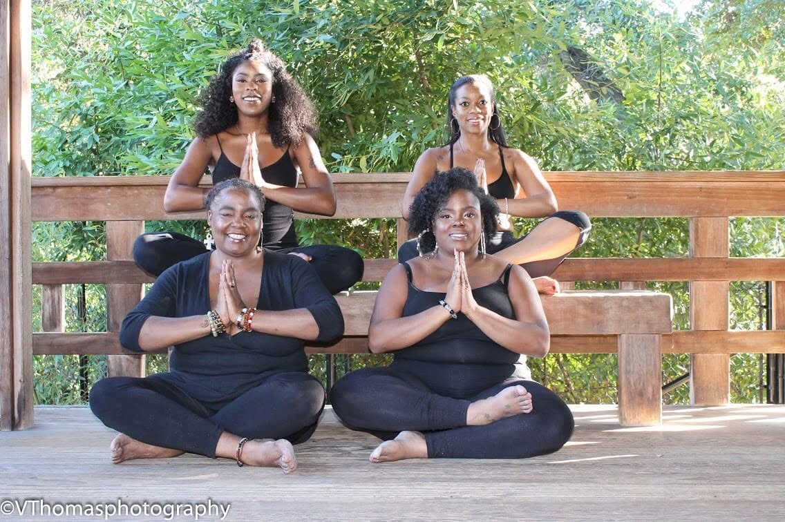 Four women sharing an outdoor group yoga practice